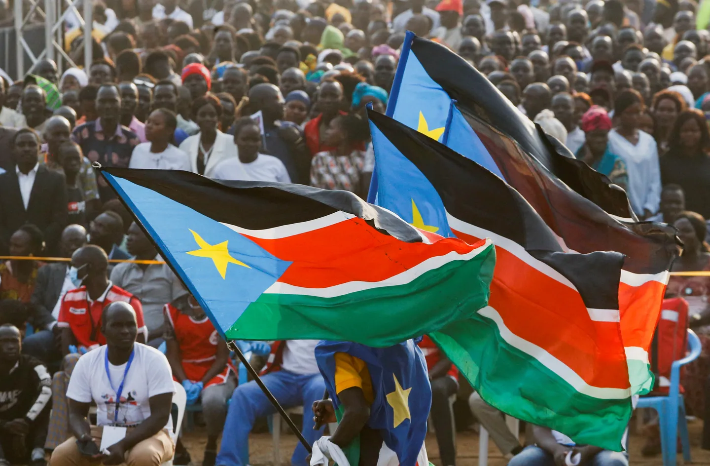 FILE PHOTO: A man runs with the national flags of South Sudan in Juba.
